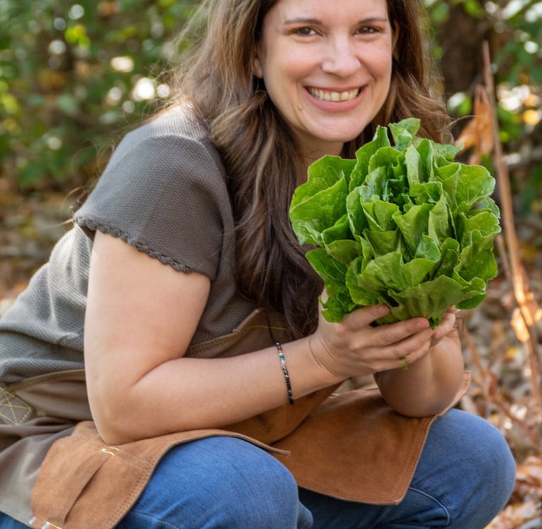 Julie Picchiotti Smiling & Holding a Freshly Harvested Head of Lettuce