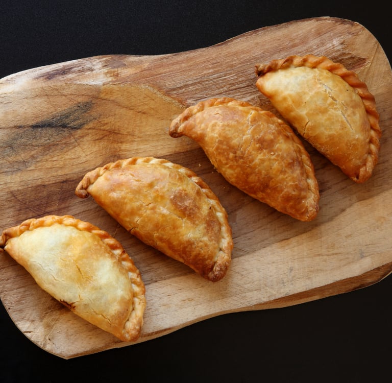 a wooden cutting board with three pastries on a cutting board