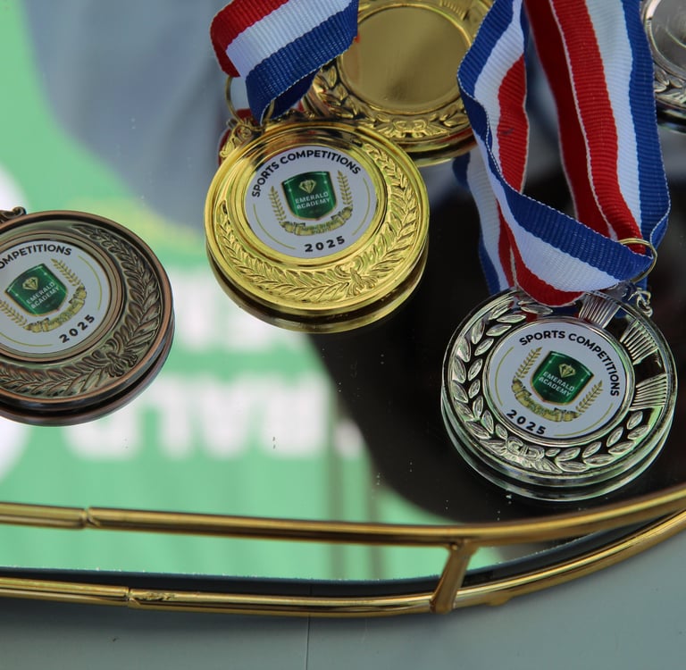 Gold, silver, and bronze sports competition medals for 2025 winners displayed on a tray.