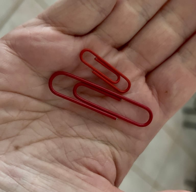 two red paper clips held in hand