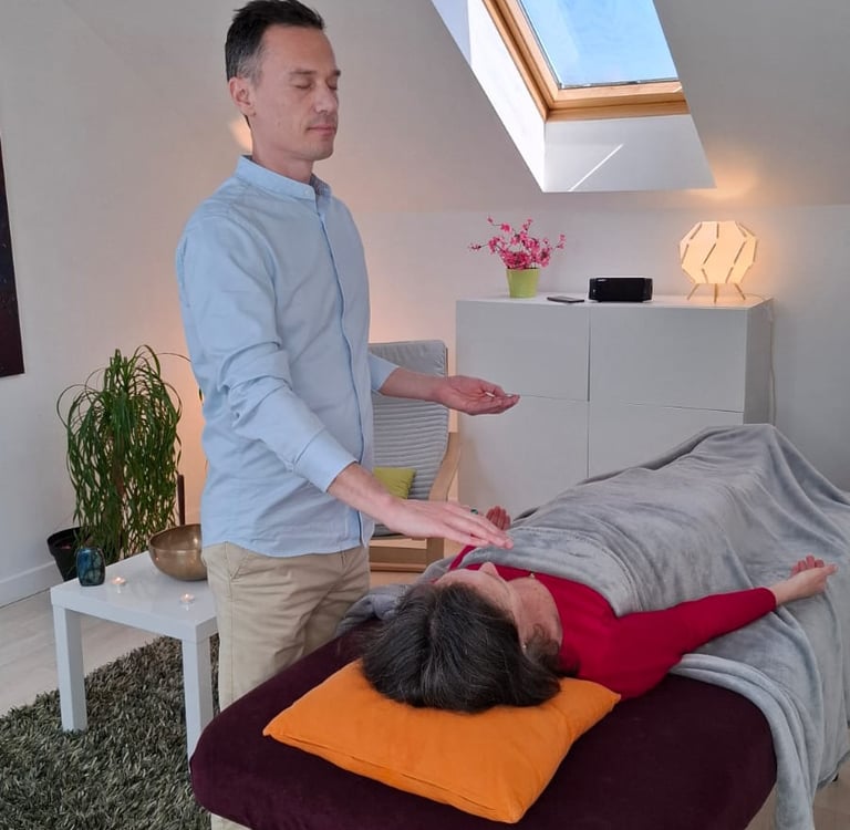 Énergéticien faisant un soin énergétique à une femme allongée sur une table de massage.