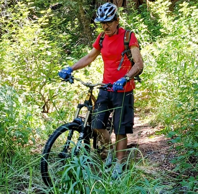 Mountain biker in the forest wearing blue mtb gloves