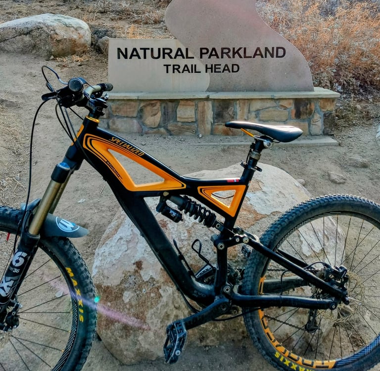 mountain bike parked in front of trail head