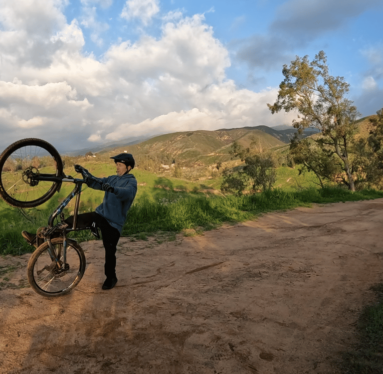 mountain biker stepping off back of bike after loopout on wheelie