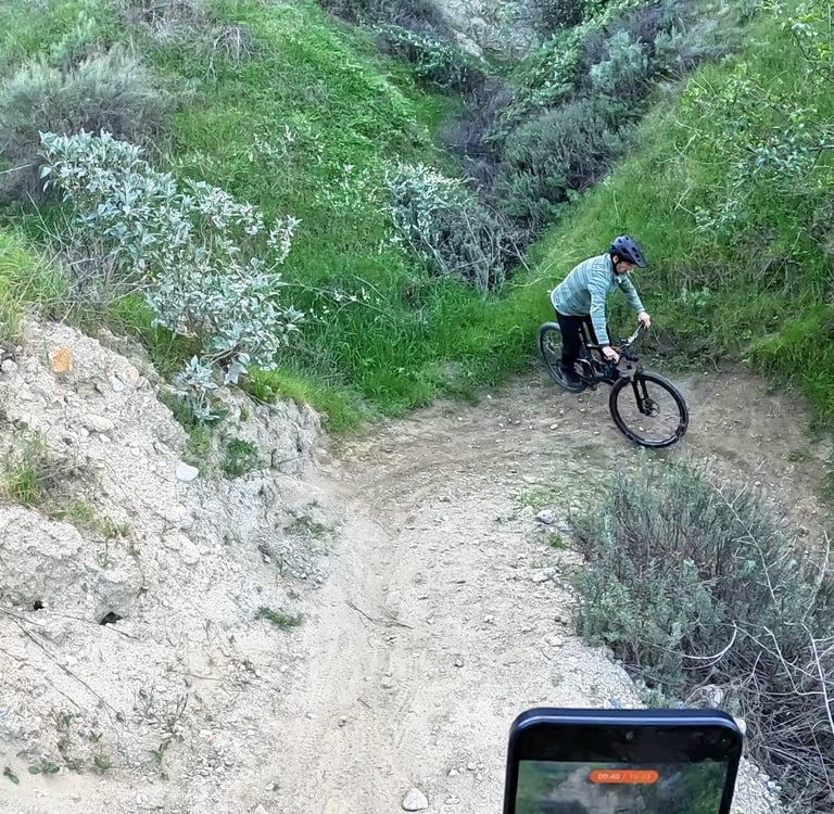 Mountain biker setting rear wheel down and straightening handlebars after completing a tight switchb