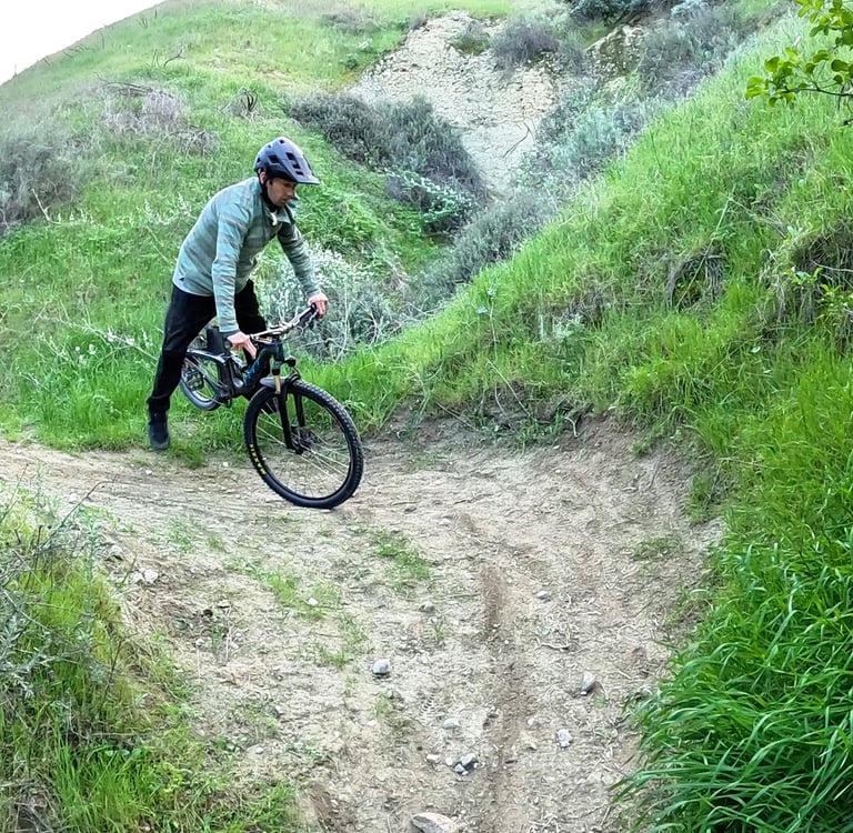 Mountain biker putting a foot down during a tight switchback due to too much weight on the inside of