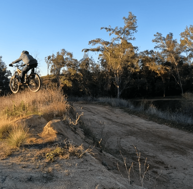 Mountain biker bringing the back wheel up with the scoop method on a jump