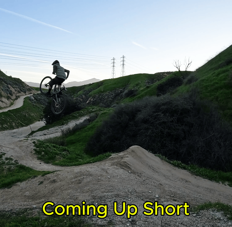 mountain biker with front wheel up high on a jump
