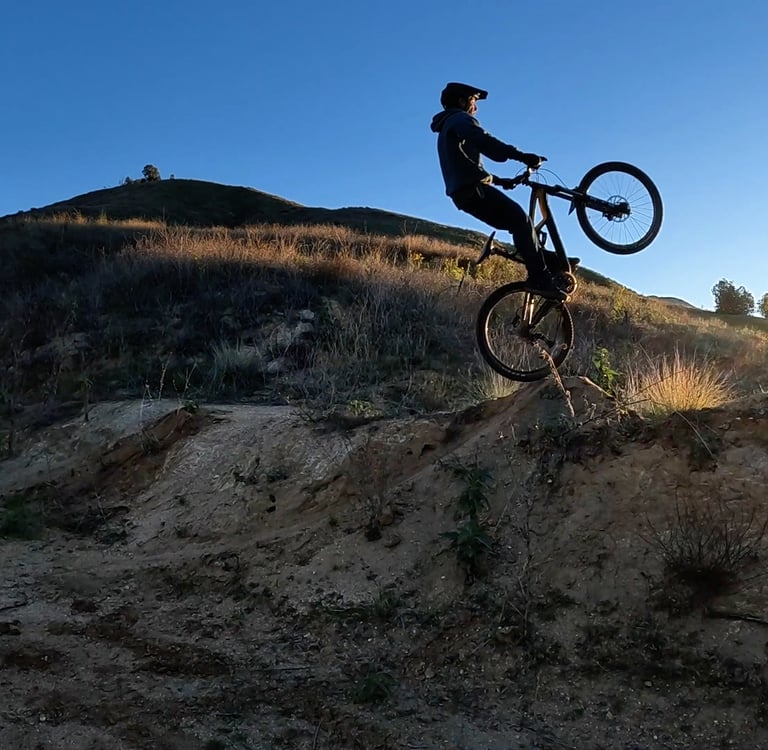mountain biker just going off a jump front wheel high in the air