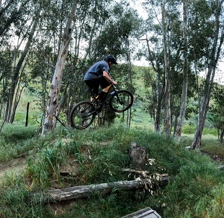 mountain biker staying low off a jump for speed