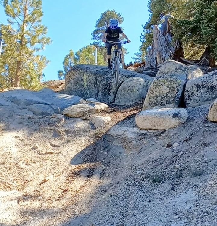 Mountain biker riding rocky terrain at Snow Valley bike park in Running Springs California on loose 