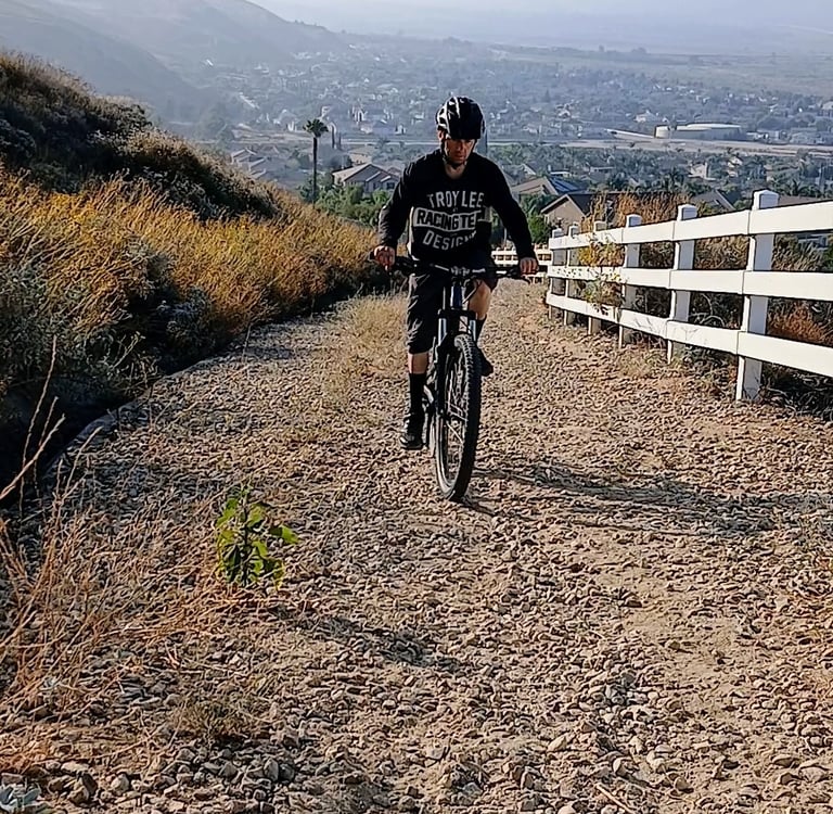 Mountain biker climbing a loose gravel trail, staying seated for traction and control
