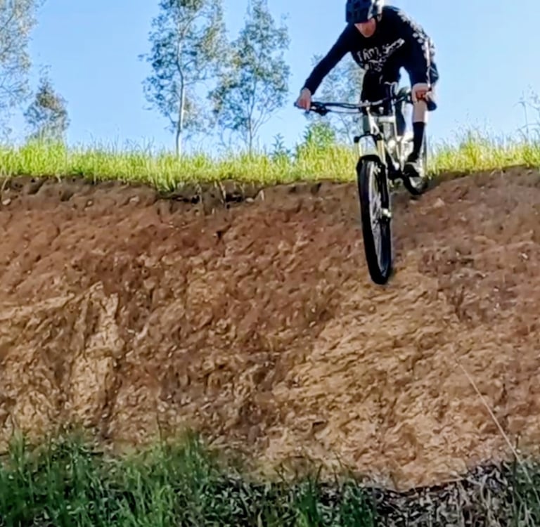mtb rider riding down a steep roll in