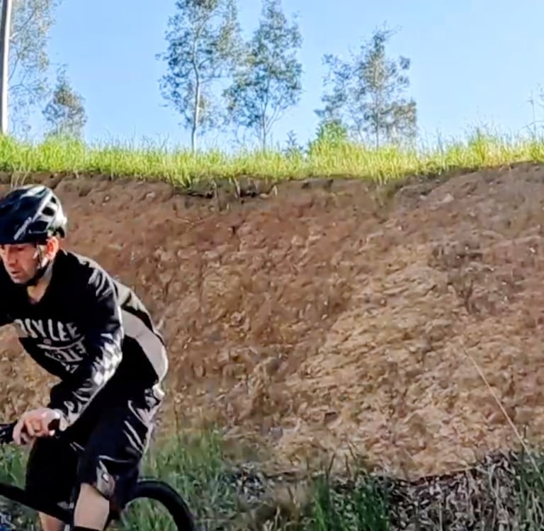 mountain biker riding out of a steep roll in