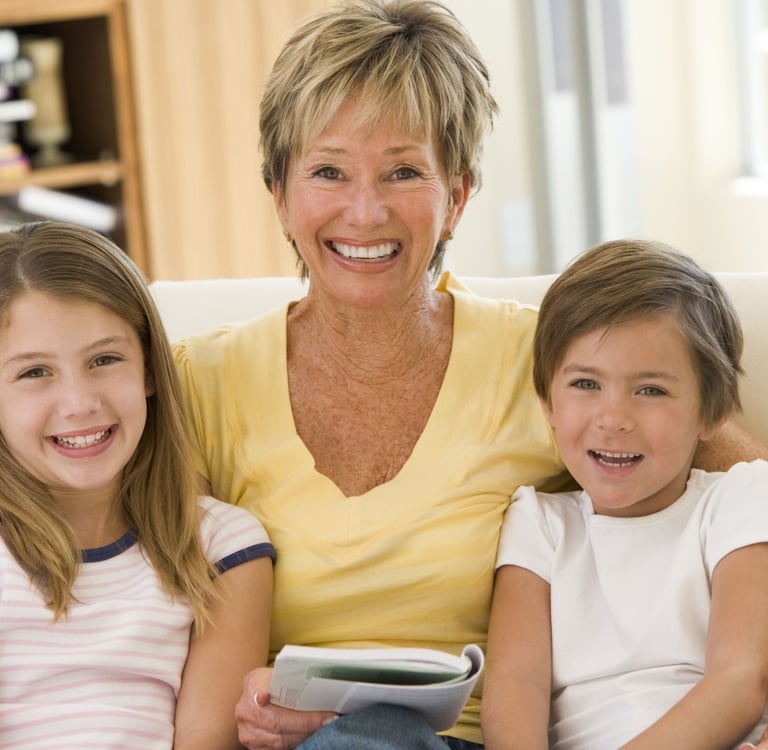 a woman sitting on a couch with two children