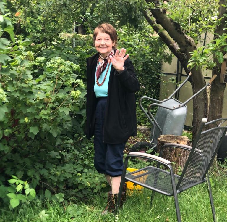 Die Mutter von Jörg im Garten. Sie winkt uns zu. Eeva Grube aus Finnland