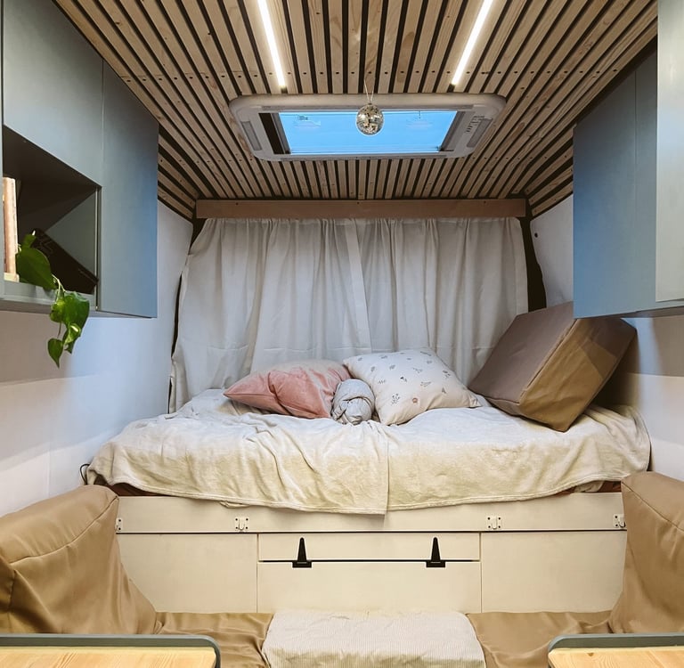 motorhome interior, a bed with some pillows on top