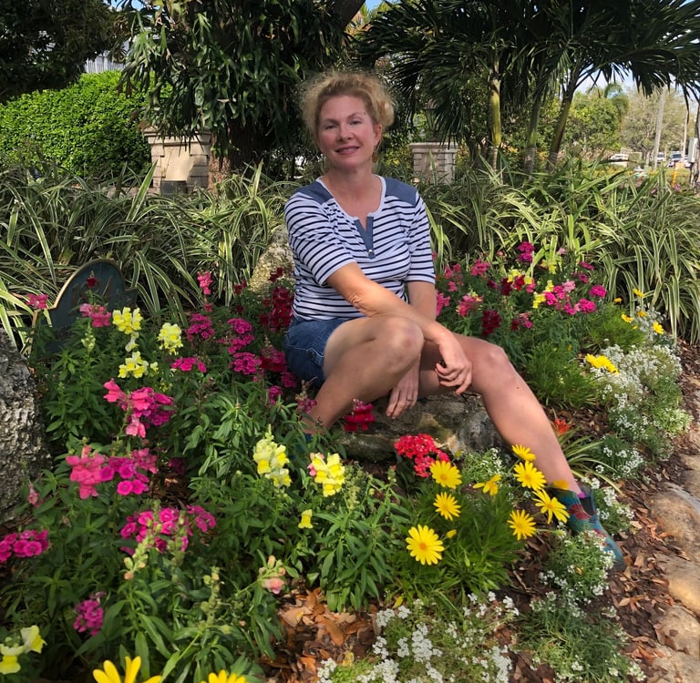 Melanie the owner sitting on a bench in a garden