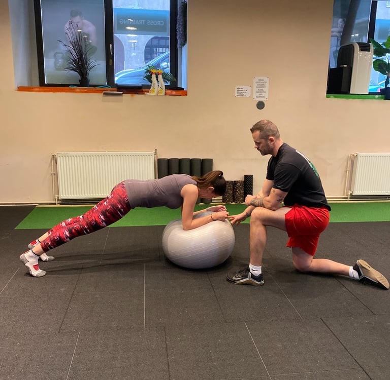 fiatal nő gimnasztikai labdán planket végez