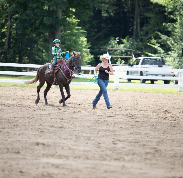 a junior riding a horse in a fenced in area