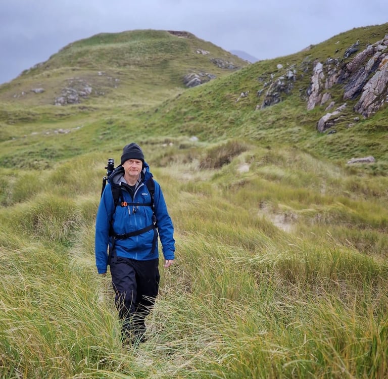 Martin Photography workshop tutor in grass carrying camera bag