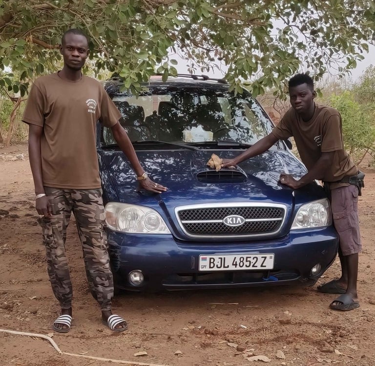 Teamleden van Birding Adventures Gambia & Senegal poseren bij een blauwe Kia safari-auto.