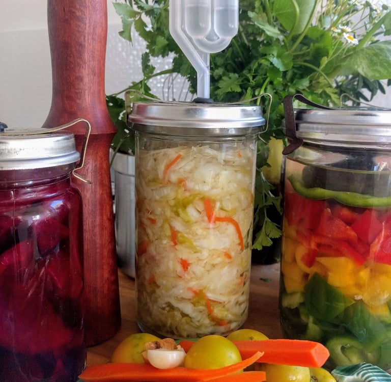 jars in colourful fermented food and wooden tamper