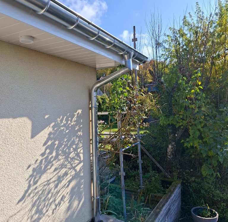 Habillage des débords de toiture en pvc blanc réalisés à Vandoncourt avec chéneaux en zinc.