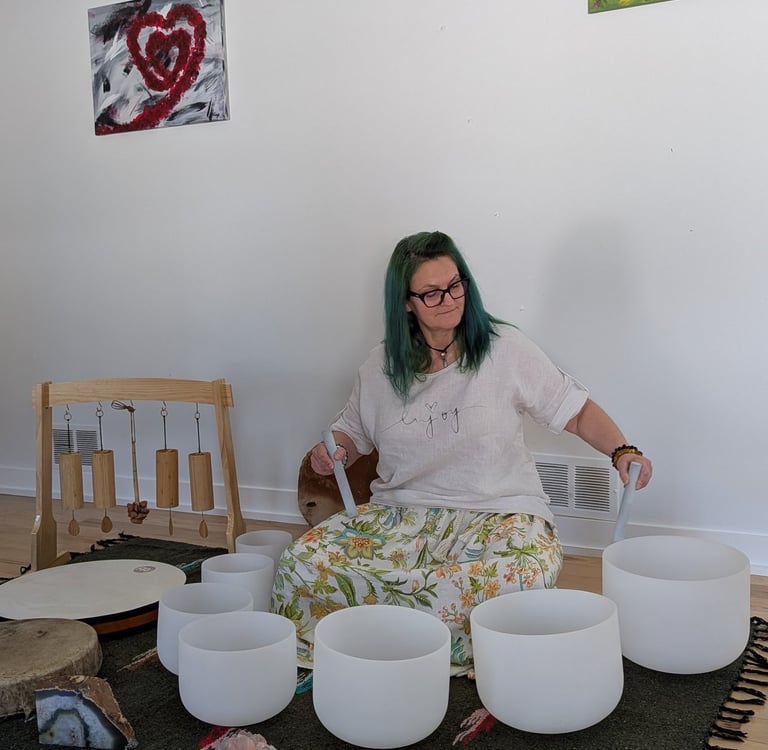 A woman playing on the sound bowls