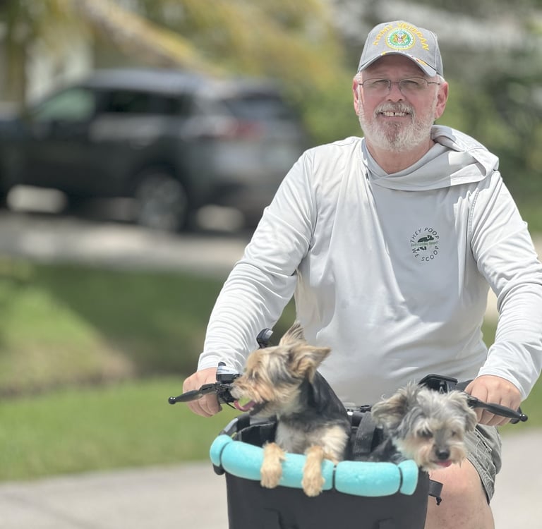 a man riding a bicycle with two dogs in a basket