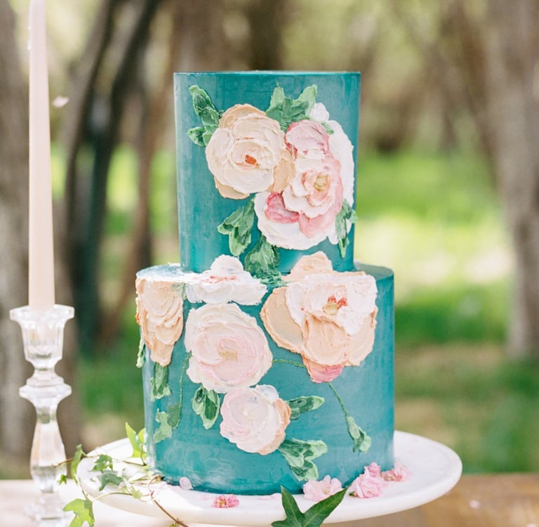 A fun blue wedding cake with buttercream flowers for luxurious Montana wedding