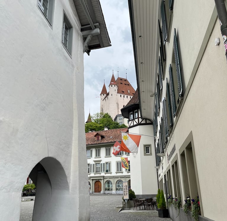 View of Thun Castle, the Thun city flag, the Swiss flag, and the flag of the Canton of Bern