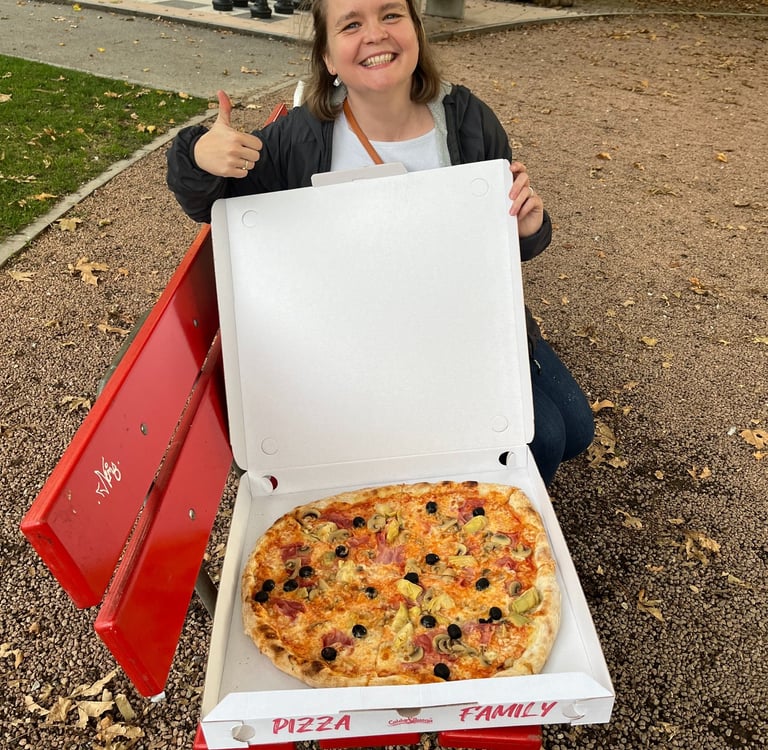 Corinne from Hidden Switzerland Travel with a massive pizza in Bellinzona