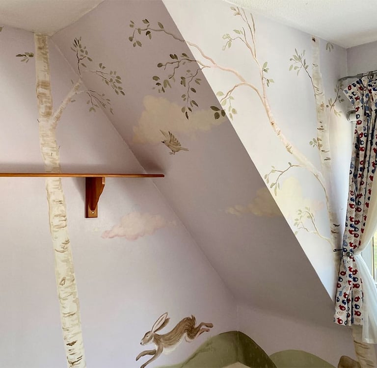 Wide angle on a wrap-around kid’s mural with a painted birch grove and a hare jumping on green ground.