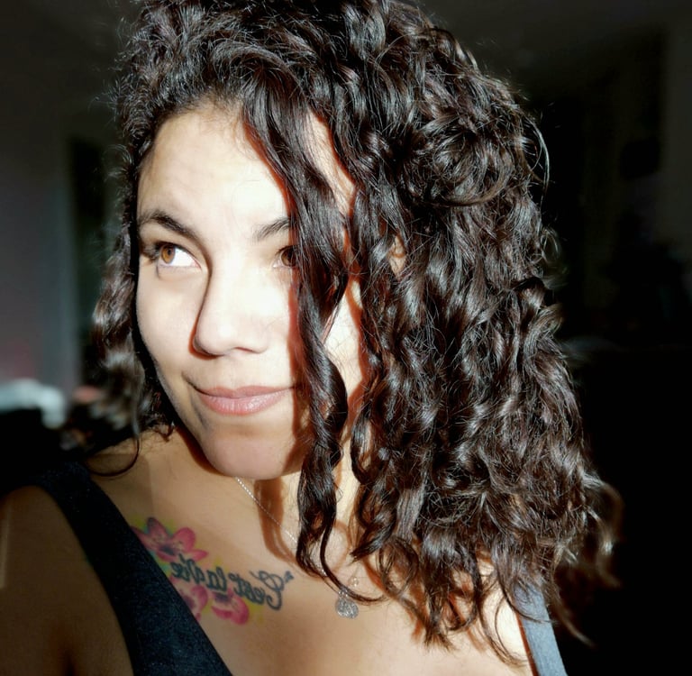 Portrait de Suzi Santana, regard éveillé et tatouage de rose, symbole de reconnaissance intuitive