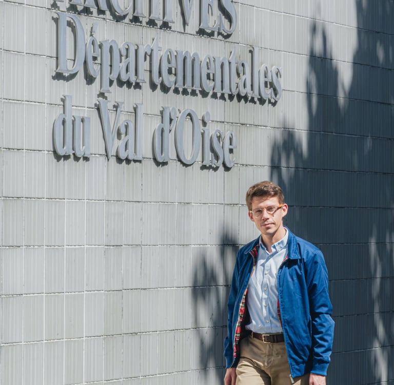 David Quentin, candidat RN-UDR aux élections municipales de 2026 à Domont, marche devant la façade d