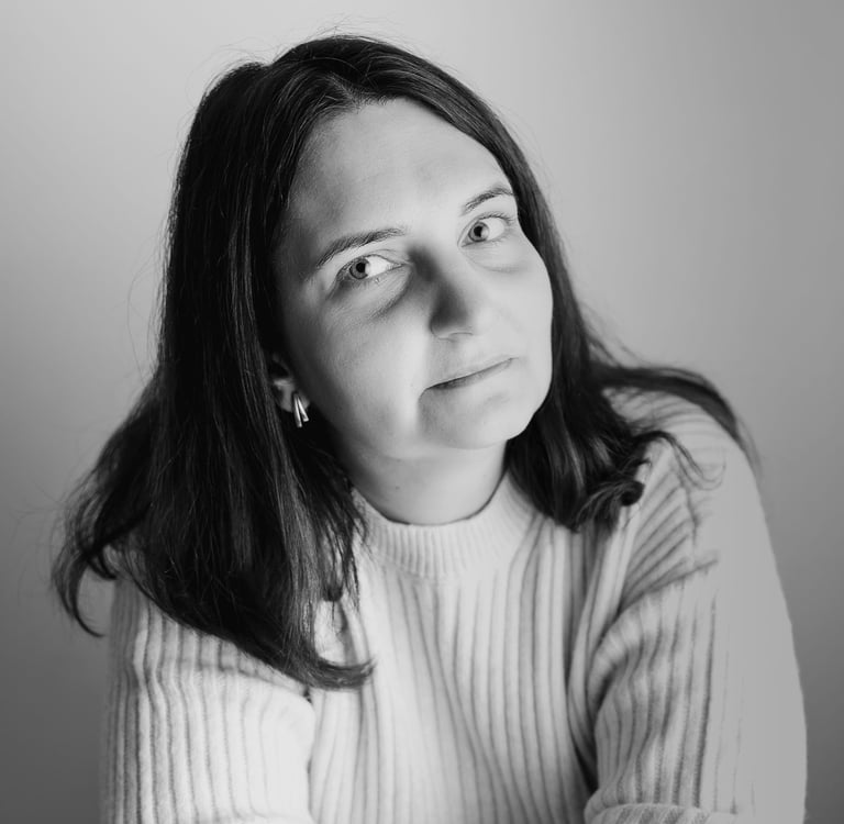 Black and white professional headshot of a woman with medium-length dark hair wearing a ribbed sweater.