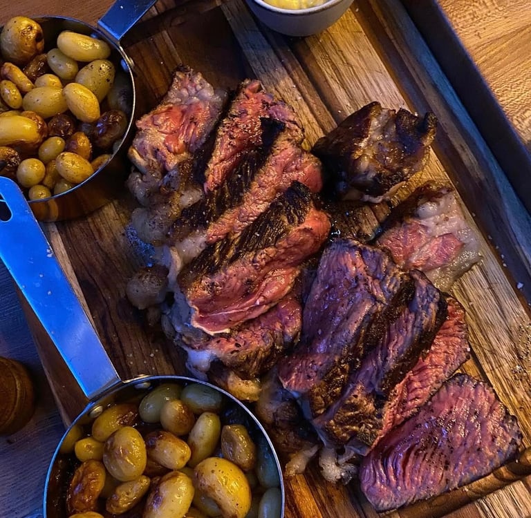 Une côte de bœuf découpée, accompagnée de pommes de terre grenaille.