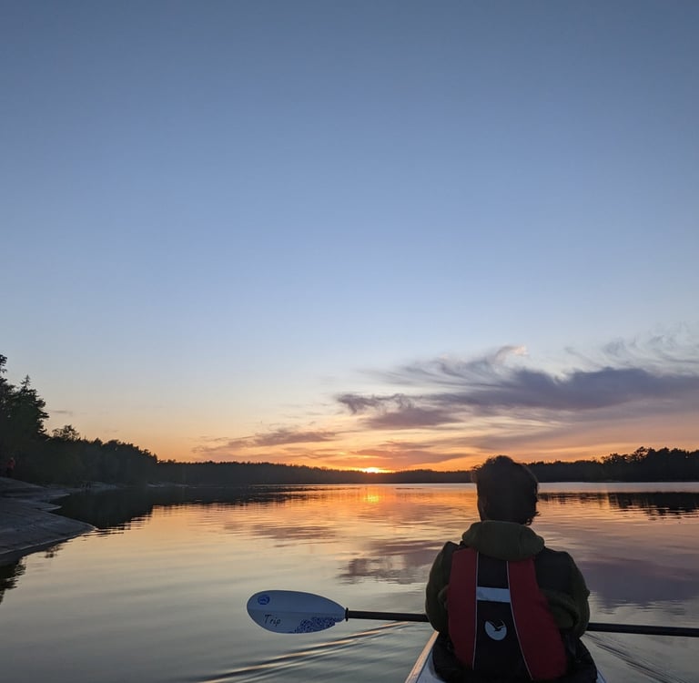 a person in a kayak paddling through the water (archipelago in Stockholm)