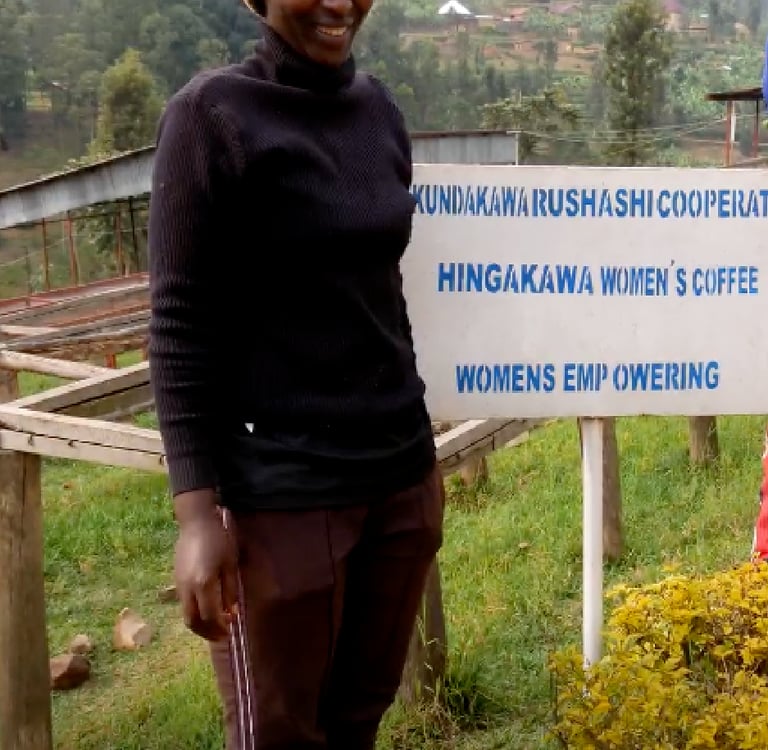 a woman standing in front of a sign that says, women"s coffee famers