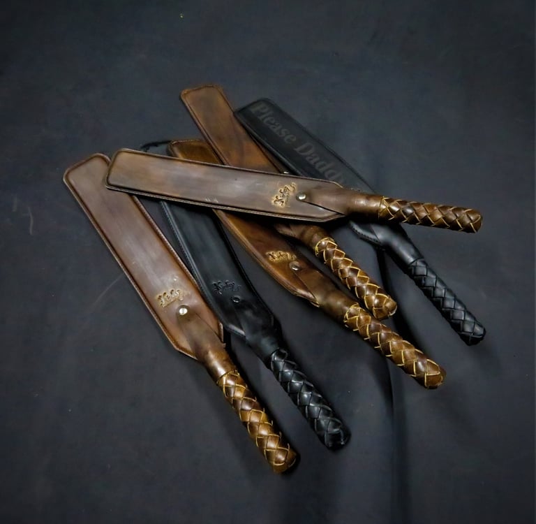a set of leather paddles with braided handles