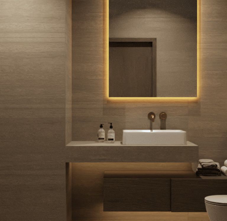 Bathroom mirror with integrated cove lighting, a white sink and dark wood vanity with underlighting