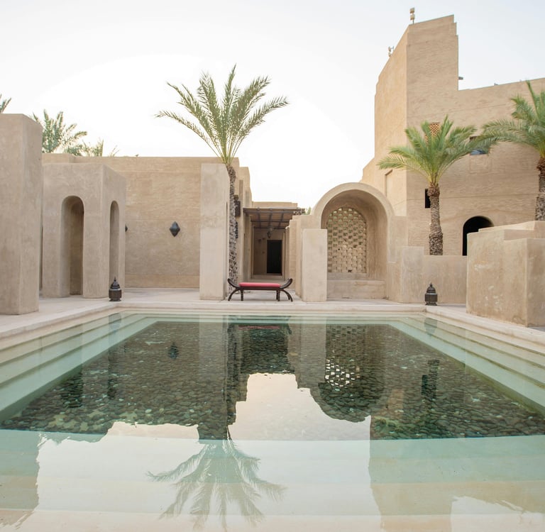 Minimal desert courtyard with reflecting pool and arched architectural walls