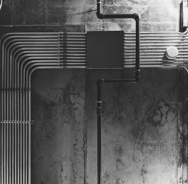Neatly organized exposed electrical conduits on an industrial concrete wall for MEP planning.