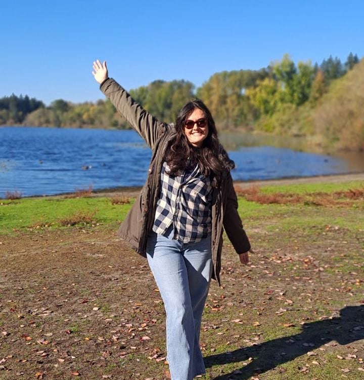 a woman standing in front of a lake