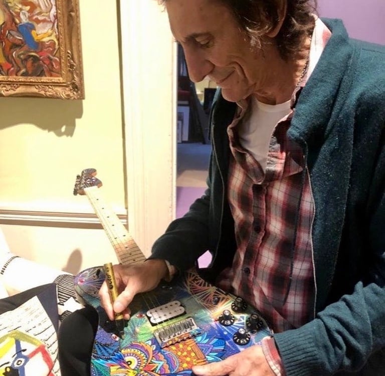 Ronnie Wood of the Rolling Stones singing - autographing my painted guitar.