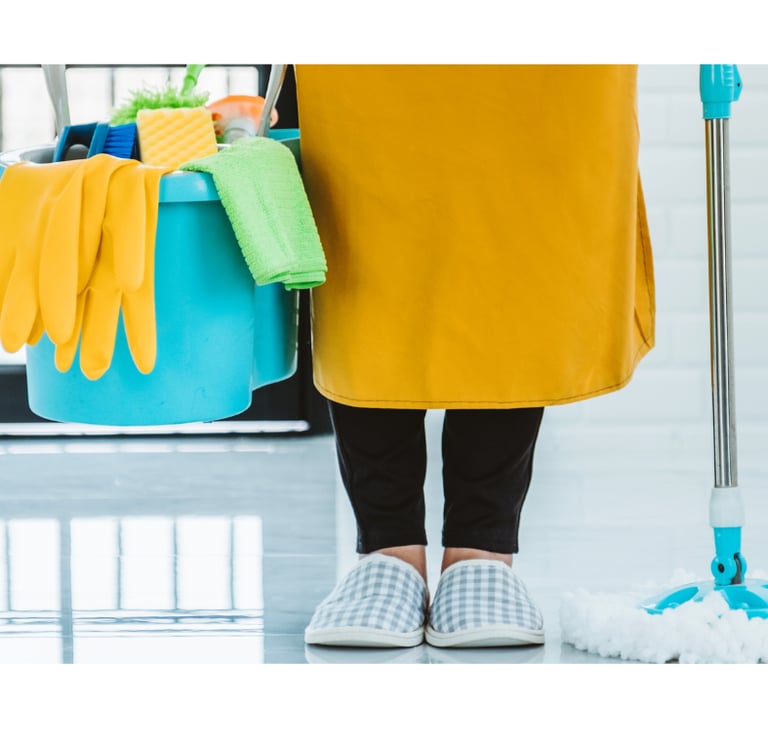 a woman in a yellow dress holding a mop and cleaning supplies