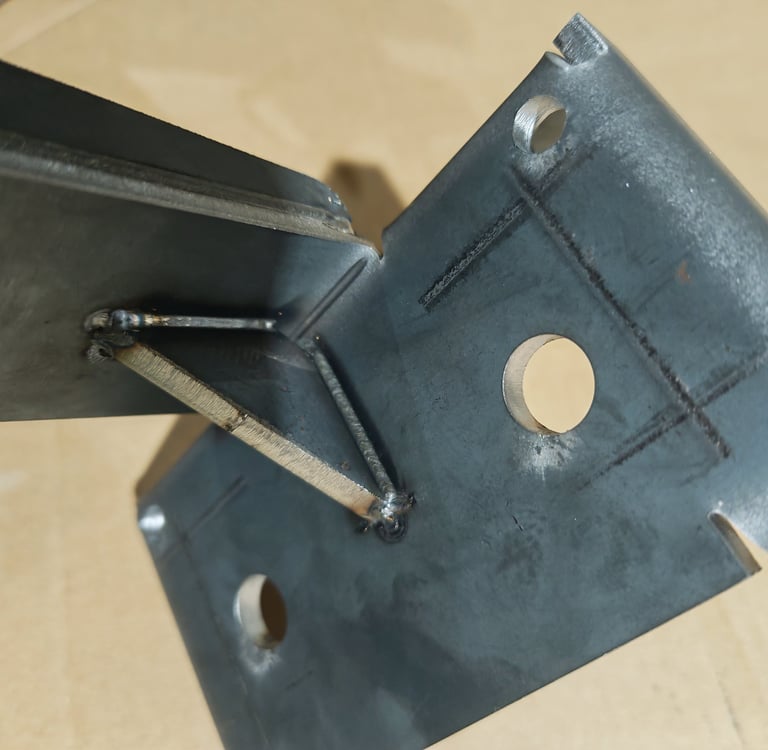 Close-up of a structural steel bracket with a welded gusset plate for metal fabrication reinforcement.