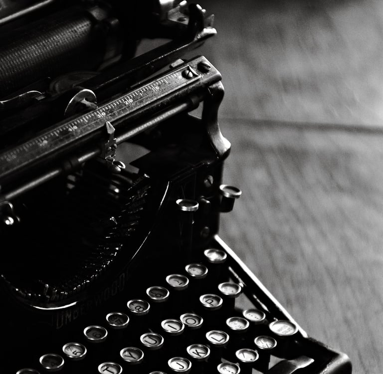 A vintage Underwood typewriter in black and white featuring classic round keys on a wooden desk.