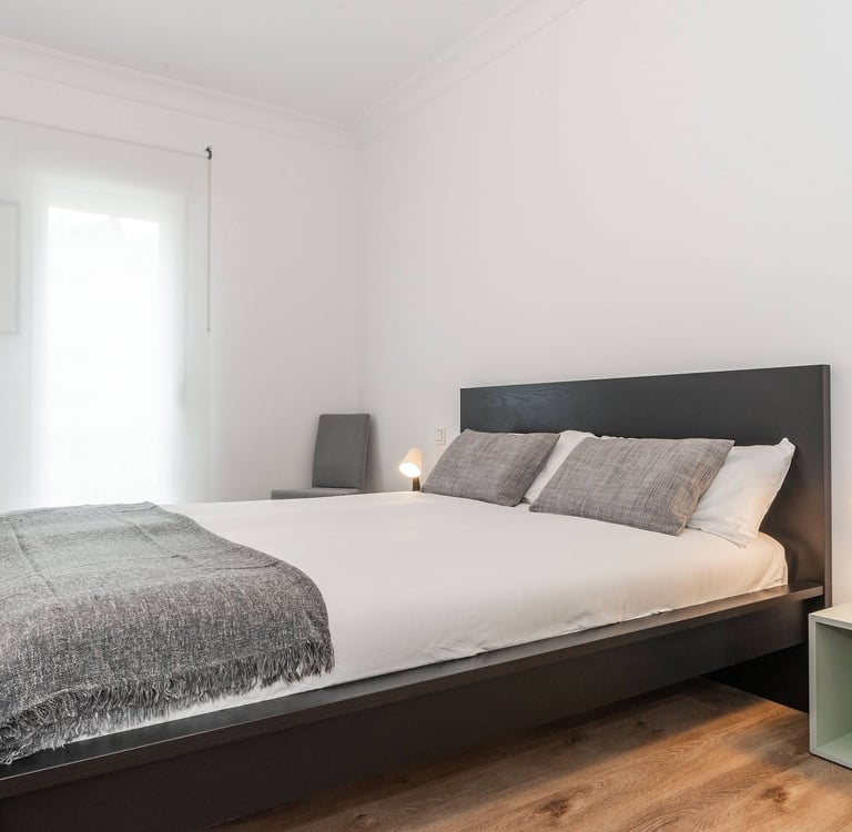 Double bedroom with dark wood bed frame, Anne apartment San Sebastian